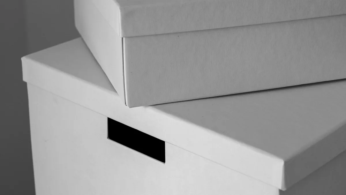 Boîtes de rangement blanches empilées, sans aucune marque, gros plan